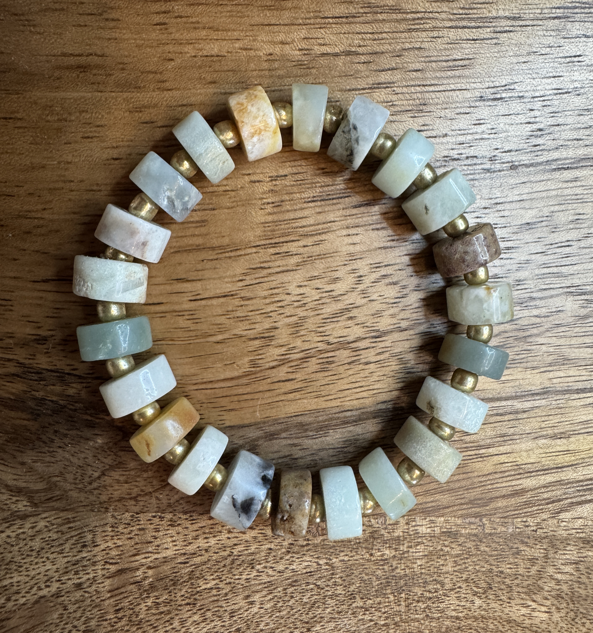 Coastal Stone stretch bracelet featuring 6mm Aqua Amazonite heishi beads in soft aqua, cream, gray and warm natural tones, accented with small gold seed beads.