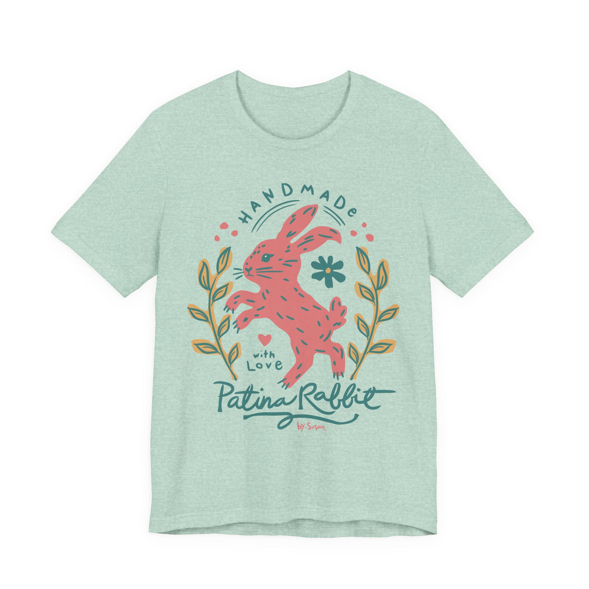 A mint green heathered t-shirt featuring a colorful graphic of a pink rabbit with the text 'HANDMADE with Love Patina Rabbit' and decorative leaves.