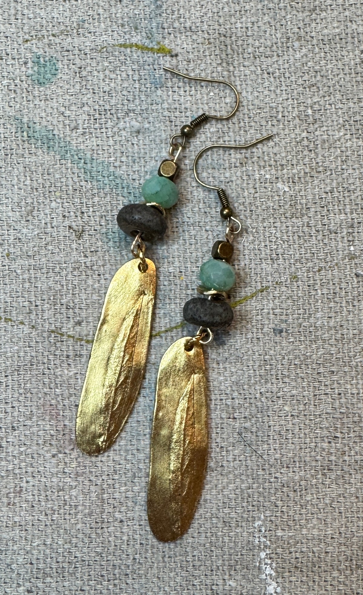 Golden Aqua Earrings by Patina Rabbit featuring handmade dark ceramic focal beads, soft aqua faceted Amazonite gemstones, and long textured gold Nunn Design pendants in a rustic artisan style.