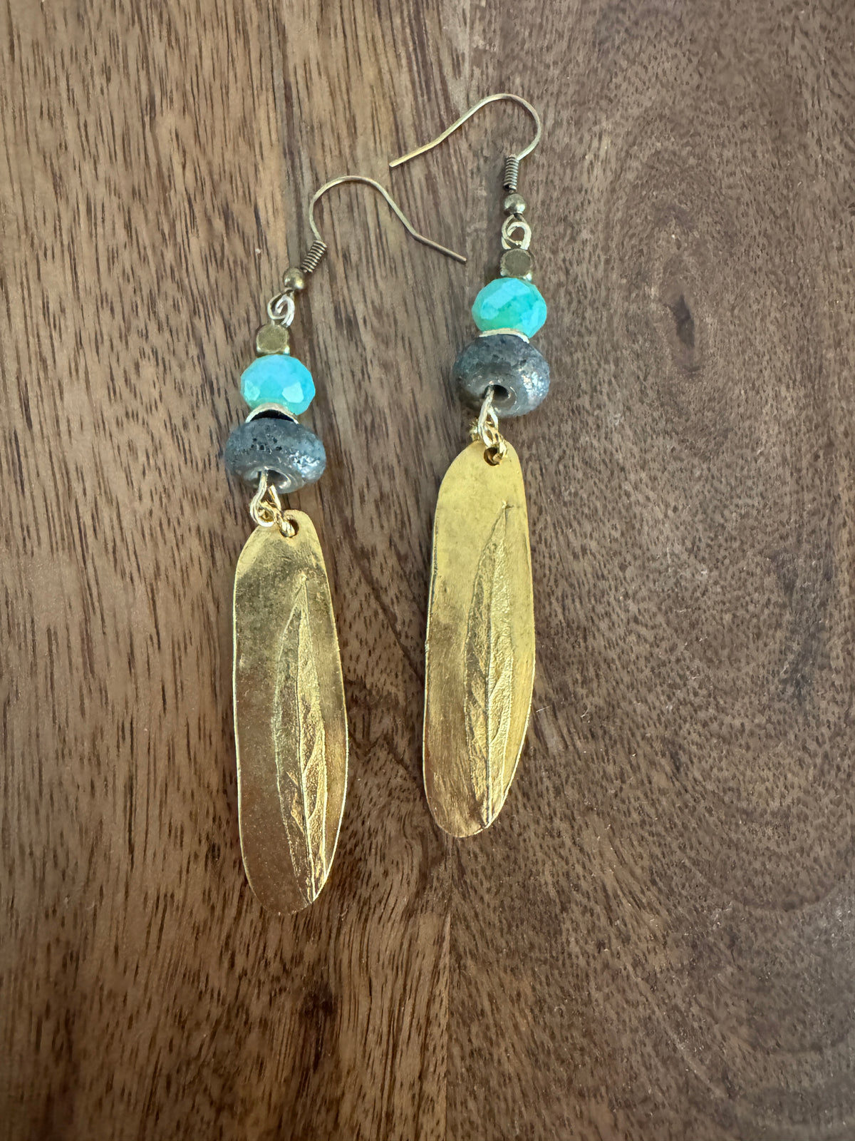 Golden Aqua Earrings by Patina Rabbit featuring handmade dark ceramic focal beads, soft aqua faceted Amazonite gemstones, and long textured gold Nunn Design pendants in a rustic artisan style.