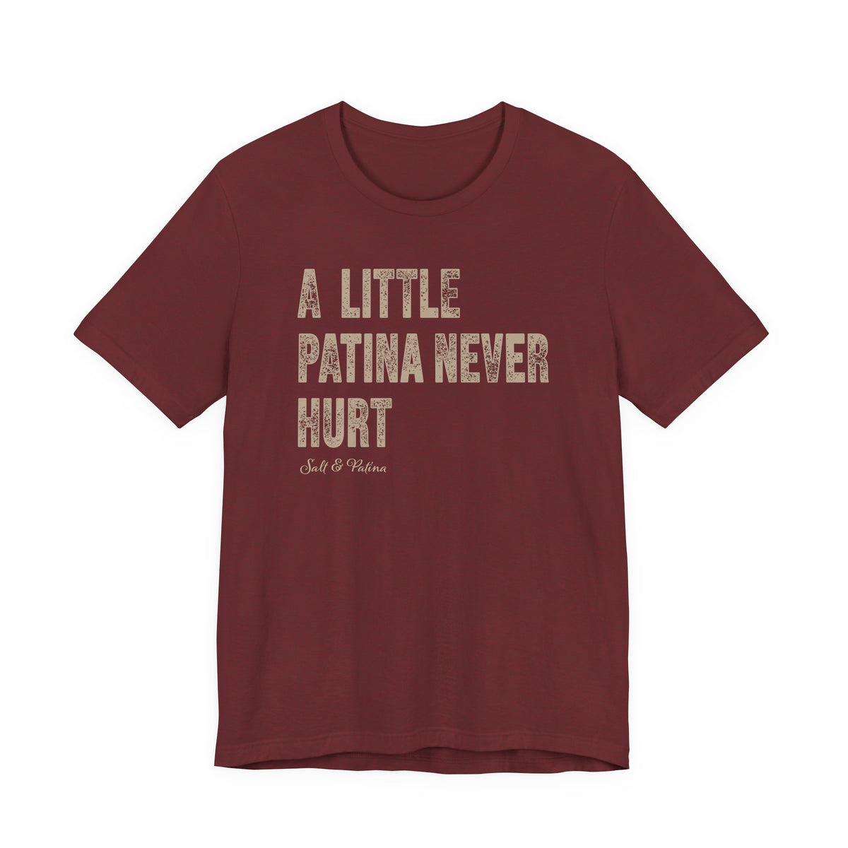 A heathered maroon blue short-sleeve t-shirt with the phrase 'A LITTLE PATINA NEVER HURT' printed in distressed beige block letters on the front, with a small 'Salt & Patina' logo underneath, shown against a plain white background.