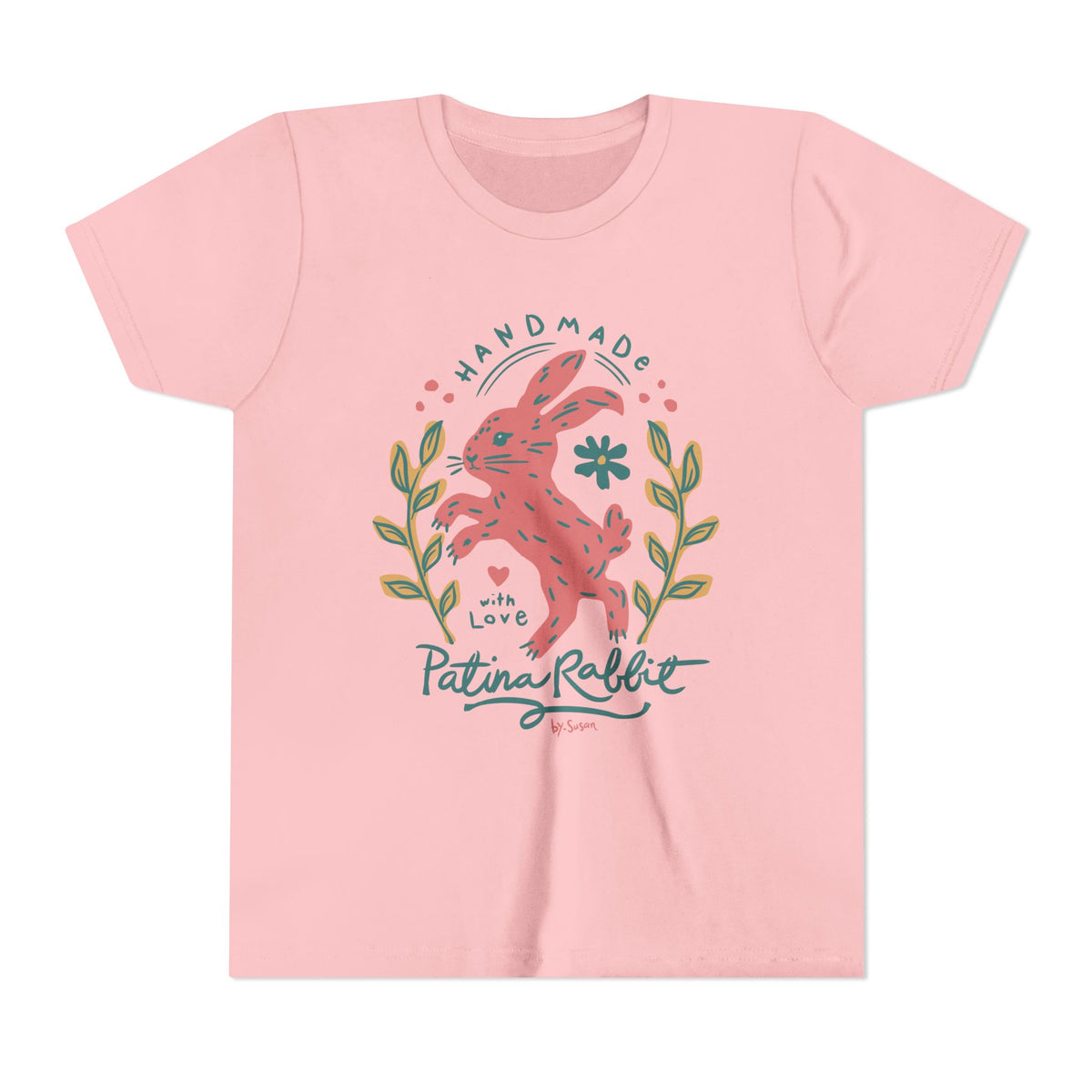 A light pink short-sleeve t-shirt with a central graphic of a pink rabbit surrounded by green leaves and blue text reading 'HANDMADE with Love Patina Rabbit'.