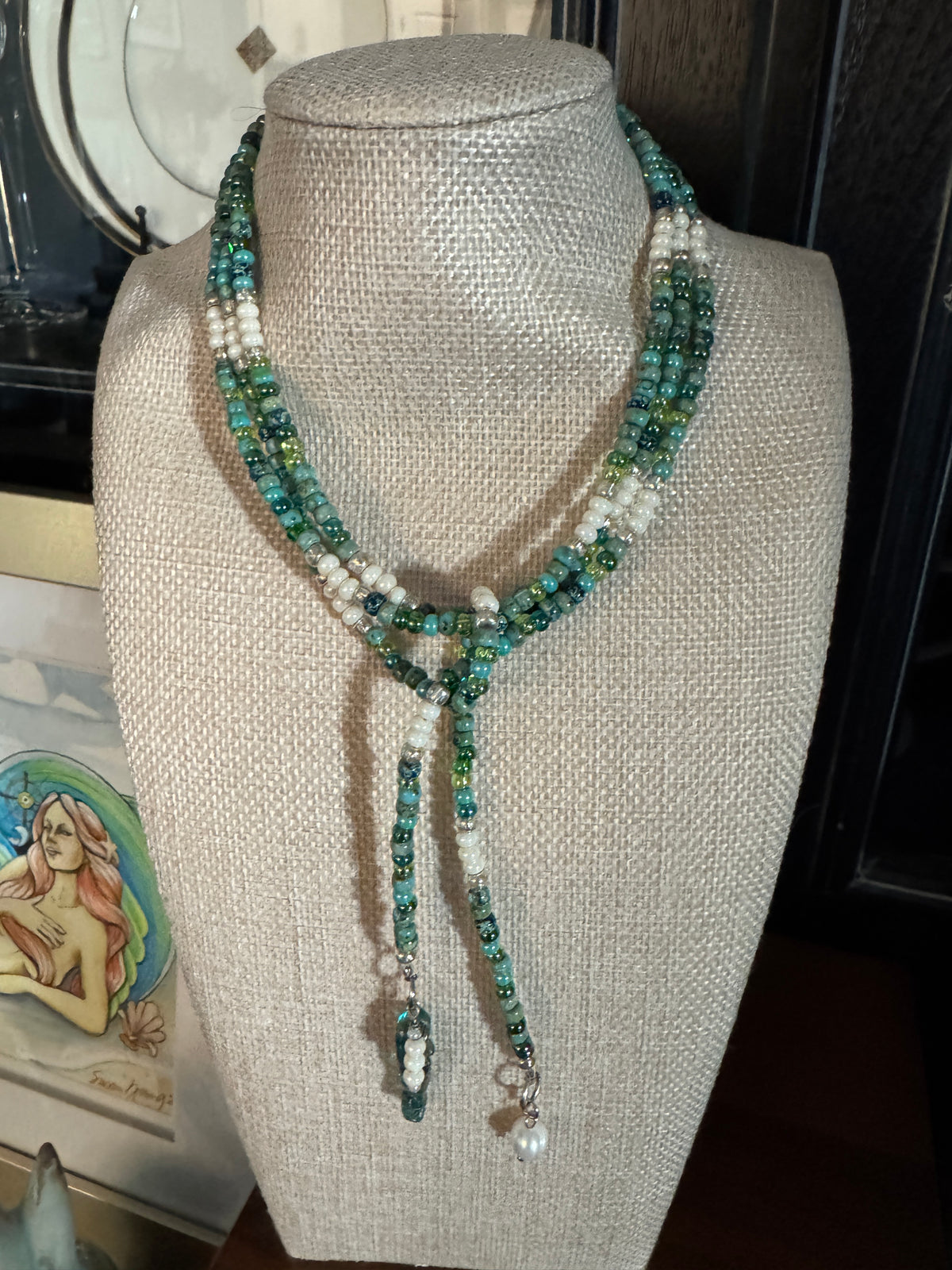 Blue Lagoon 48-inch handmade lariat necklace with turquoise, blue, green and white beads, silver accents. With a mermaid and pearl drop.