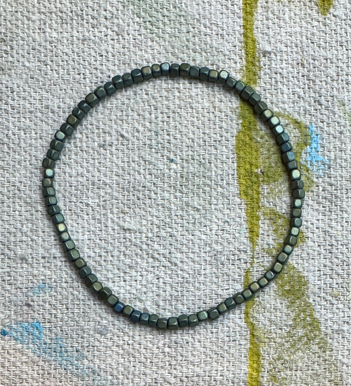 Little Layers Matte Teal stretch bracelet featuring tiny 2mm reconstituted hematite cube beads in a softly weathered teal finish.