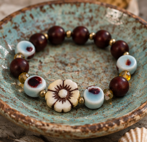 Patina Rabbit handmade stretch bracelet with rosewood beads, aqua ceramic beads, cream flower bead and gold accents.